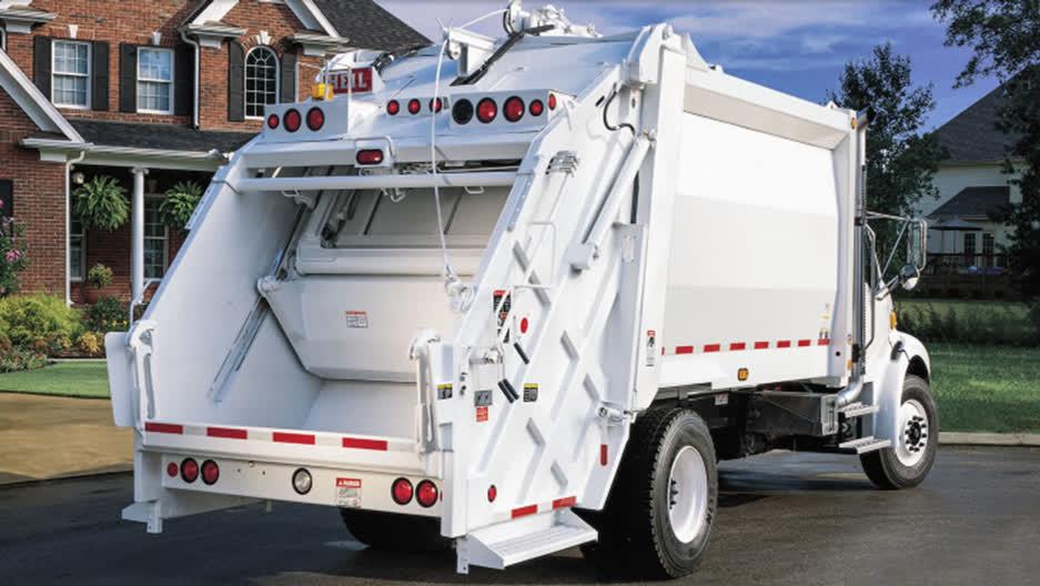 Heil rear load garbage truck backing up for collection